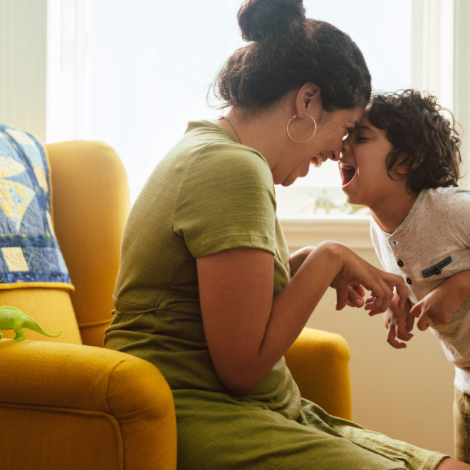 Young Mother And Son Imitating A Dinosaur At Home