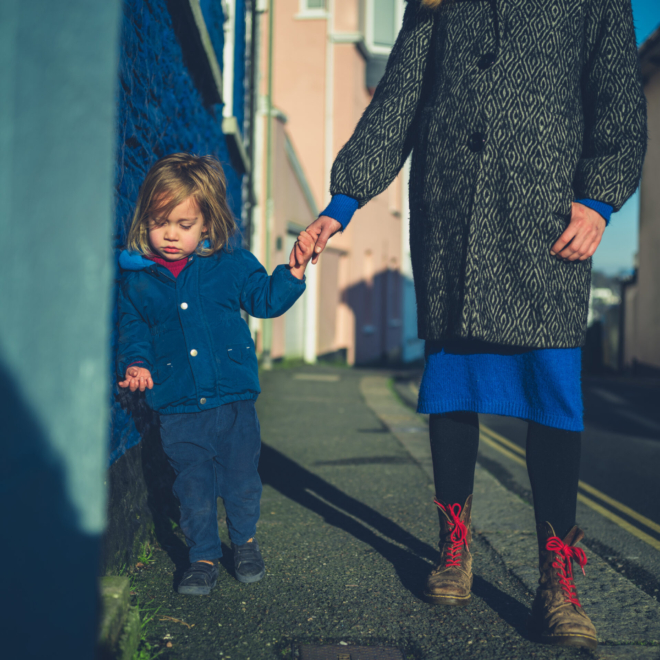 Mother And Toddler Holding Hands On Walk In Winter